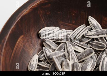 Pile of roasted sunflower seeds in wooden bowl close up Stock Photo