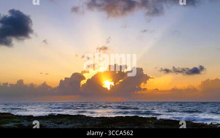 Sunrise in the Mexican Caribbean on a rocky coastline with foaming waves and dramatic cloud formation, Riviera Maya, Mexico Stock Photo