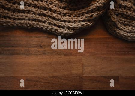 Knitted brown wool blanket on wooden table surface with copy space Stock Photo