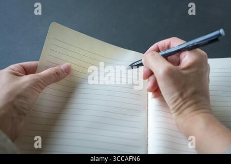 Female writing on notepad. First person point of view. Stock Photo