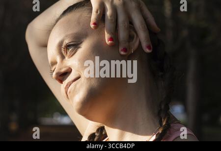 Sporty woman doing relaxing stretching exercises. Stretching the neck in front of training Stock Photo