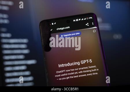 Dhaka, Bangladesh- 09 aug 2025: A smartphone screen displaying the OpenAI GPT-5 with the website is visible on a computer screen in the background Stock Photo