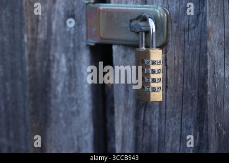 A gold lock with a key hanging from it Stock Photo