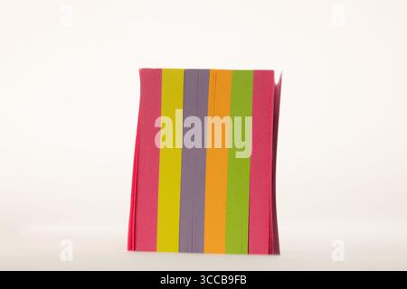 A stack of colorful sticky notes standing upright against a clean white background Stock Photo