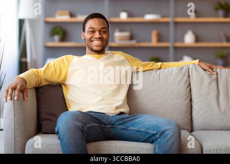 Relaxed african american man resting on sofa at home Stock Photo
