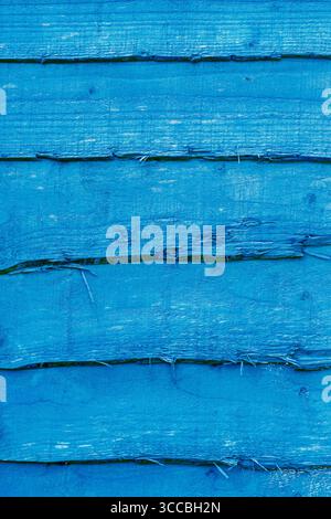 Blue stained rustic wooden fence panel background backdrop. Garden boundary structure concept. Stock Photo
