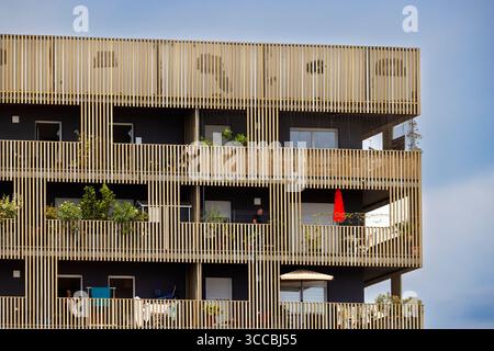 Architectural detail of a modern residential building featuring wooden balconies, promoting sustainable urban living Stock Photo