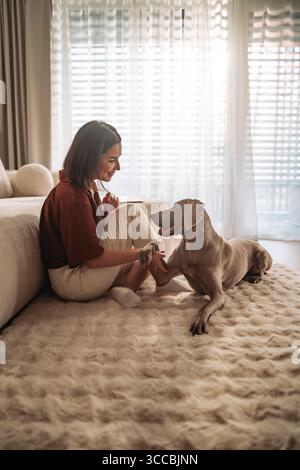 Cozy Moments A Woman Enjoying Special Bonding Time with Her Dog at Home Stock Photo