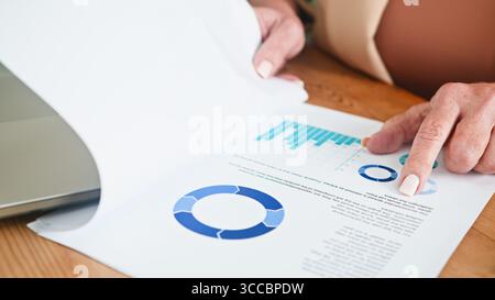 Senior Woman Analyzing Business Data and Charts on Printed Documents Stock Photo