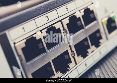 Close-up view of a network switch featuring several Ethernet ports, commonly found in offices and data centers, facilitating wired internet connection Stock Photo
