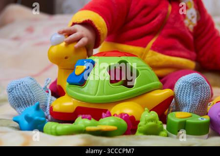 feet baby playing with toys on the bed Stock Photo