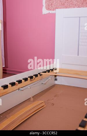 assembling a white bed in the bedroom, new bedroom furniture Stock Photo