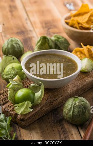 Fresh and tangy salsa verde sauce made from tomatillos, served with crispy tortilla chips. Perfect for Mexican cuisine, party snacks, and healthy appe Stock Photo