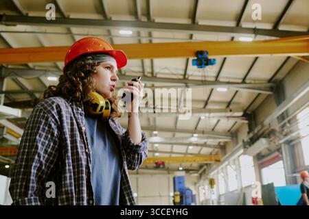 Young Adult Caucasian Woman Supervising Construction Site Using Walkie Talkie Stock Photo
