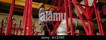 Header of Woman Wearing Hard Hat Climbing Industrial Metal Stairs Stock Photo