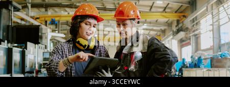 Header with Caucasian Women Collaborating Using Digital Tablet in Factory Stock Photo