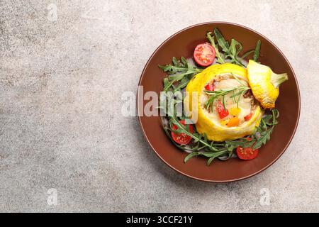 Tasty stuffed pattypan squash with tomatoes and arugula on grey table, top view. Space for text Stock Photo