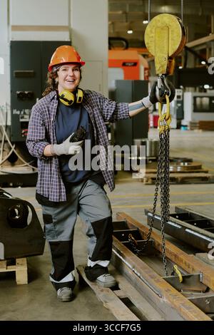 Young Adult Caucasian Woman Operating Industrial Crane in Factory Setting Stock Photo