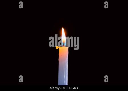 Lit and unlit candles in a candelabra against a dark background, evoking warmth and memory. Stock Photo