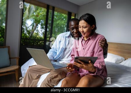 Couple of freelance IT specialists using digital technology devices while working remotely from home Stock Photo