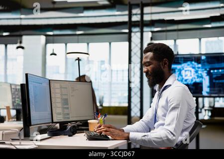System administrator in office training machine learning models for anomaly detection automation. Tech startup IT specialist using artificial intelligence to monitor for network issues Stock Photo