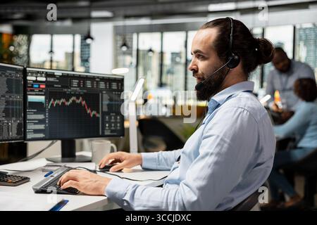 Financial advisor in office speaking in audio headset mic, working with clients to develop personalized investing strategies. Consultant chatting with customers, providing stock market guidance Stock Photo