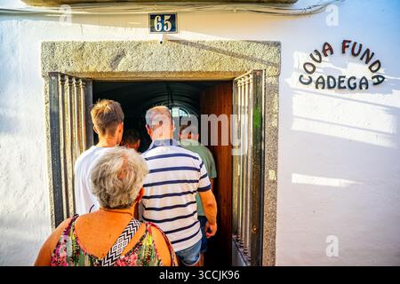 Group of elderly people with their backs turned entering the Cova Funda wine cellar in the Alentejo town of Redondo, Portugal. Stock Photo