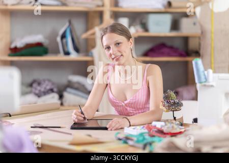 Woman dressmaker makes pattern using tablet Stock Photo