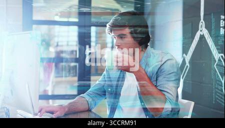 Working tech analyst monitoring data overlays on large monitor at office desk, with coffee mug Stock Photo