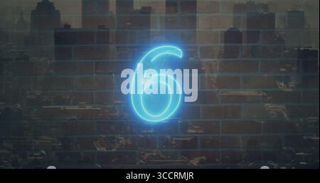 Glowing neon six sign casting blue light on red brick wall at dusk, with city skyline Stock Photo