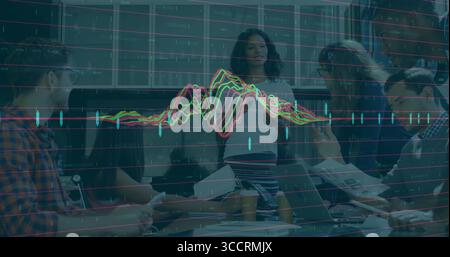 Woman wearing striped skirt presenting data overlays in conference room with laptops coffee cups Stock Photo