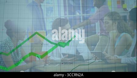 Collaborating five employees analyzing graphs at wooden table in office, with laptop and tablets Stock Photo