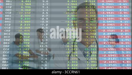 Walking doctors in lab coats reviewing data in hospital corridor, using tablet and overlays Stock Photo