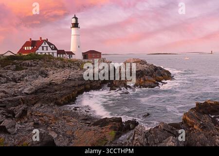 Portland Head Light at sunset surrounded by with dramatic waves and cliffs, Maine, USA Stock Photo