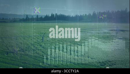 Displaying digital overlay with bar charts, line graphs and numeric labels over green crop rows Stock Photo