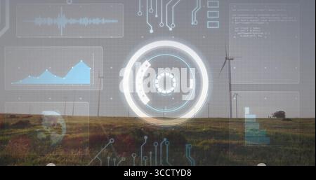 Displaying circular HUD overlaying grassy plain wind farm, with wind turbine towers and data panels Stock Photo