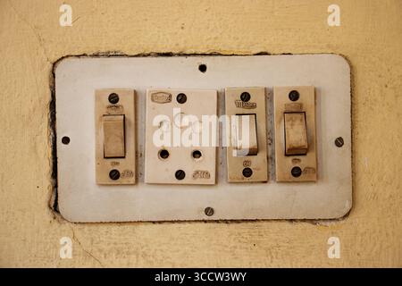 JAIPUR, RAJASTHAN, INDIA - FEBRUARY 3, 2024 3 old light switch and an outlet electrical - Alfa and mastex brand Stock Photo