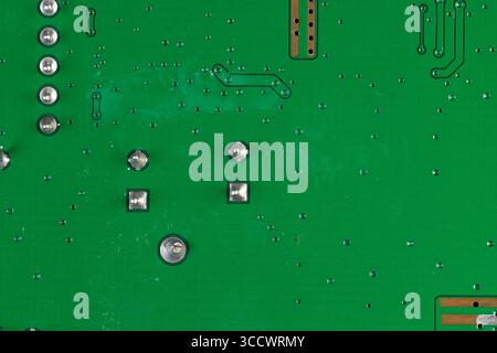 electronic circuit board with a large number of contacts, a simple green printed circuit board with an electronic circuit with soldered elements Stock Photo