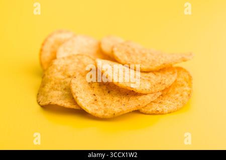 Crispy potato chips on an yellow background. Stock Photo