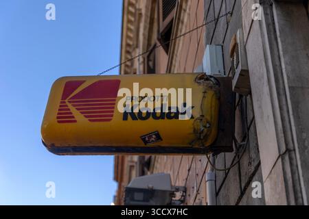 Vintage Kodak sign hangs outside a photography processing shop in Rome, Italy, evoking nostalgia and the city’s historic charm on a sunny day. Stock Photo