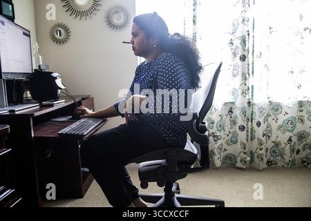November 22, 2022, Morrisville: Archana Gopal works in her home office in Morrisville, North Carolina, on Nov. 11, 2022. Gopal arrived in North Carolina in 2013 with her two young daughters and husband, Maharajan Shunmugam, who works on a H-1B visa as a software engineer. In 2021, USCIS informed Gopal that her work authorization renewal would be delayed. (Credit Image: © Travis Long/The News & Observer via ZUMA Press Wire) Stock Photo