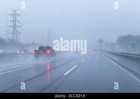 Car driving in rain on road Stock Photo