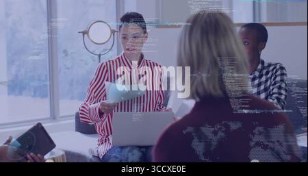 Reviewing printed documents woman in red white striped blouse leading meeting in lounge with laptop Stock Photo