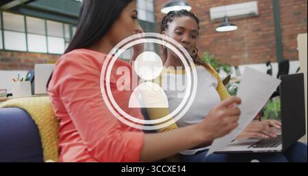 Reading printed document and typing on laptop in coworking lounge, with pencils, copy space Stock Photo