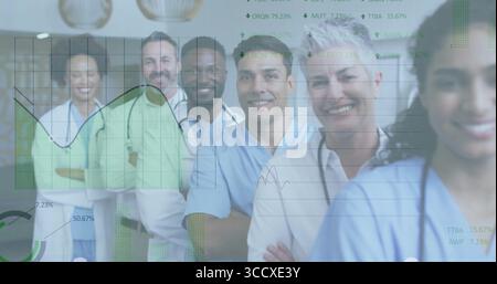 Smiling medical team wearing scrubs and lab coats in clinic hallway, with stethoscopes, line graphs Stock Photo
