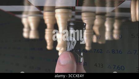 Lifting black knight chess piece above wooden pawn pieces on office chessboard, with data overlay Stock Photo