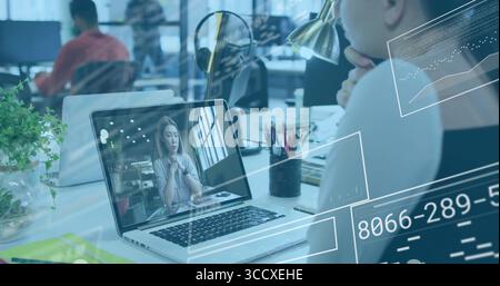 Showing silver laptop streaming conference call at office desk, with lamp pen holder and plant Stock Photo