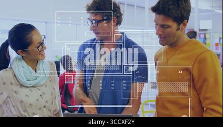 Collaborating three colleagues reviewing data overlays on laptop in open office, digital interface Stock Photo