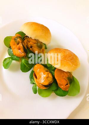 Spanish tapa: Mussels with water cress in bread. Spain. Stock Photo
