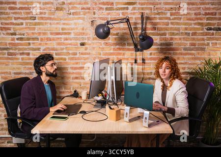 Two designers working on computers in modern office Stock Photo